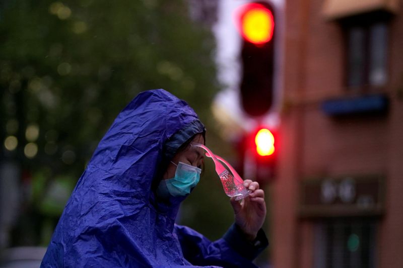 A woman wearing a face mask is seen on a street after the lockdown was lifted in Wuhan