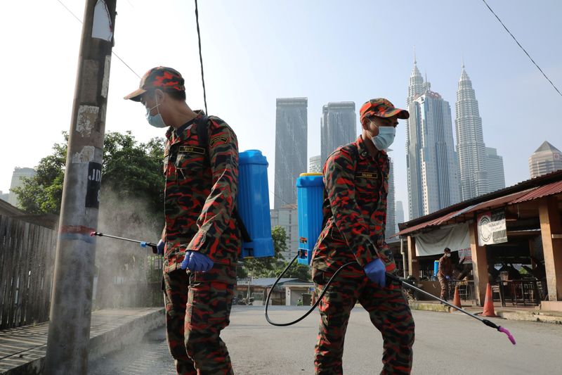 Firefighters spray disinfectant on a street during the movement control order due to the outbreak of the coronavirus disease (COVID-19), in Kuala Lumpur