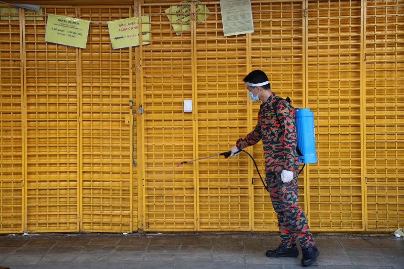 A firefighter disinfects a closed shop during the movement control order due to the outbreak of the coronavirus disease (COVID-19), in Kuala Lumpur