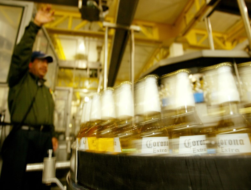 FILE PHOTO: Bottles of Mexico's world famous Corona beer speed past a worker in the bottling line of Mexico City..