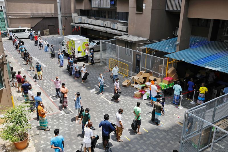 Workers adopt safe distancing measures as they queue up for lunch at Westlite dormitory during the coronavirus disease (COVID-19) outbreak in Singapore, April 10, 2020 in this picture obtained from social media