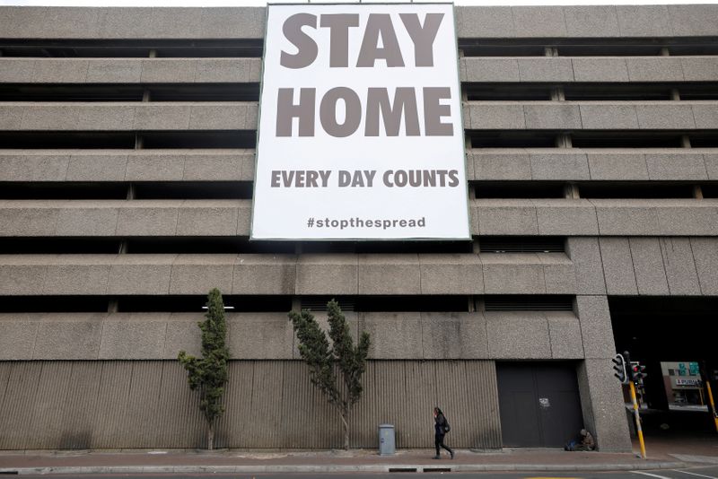 A man walks beneath a billboard during the 21-day nationwide lockdown aimed at limiting the spread of coronavirus disease (COVID-19) in Cape Town
