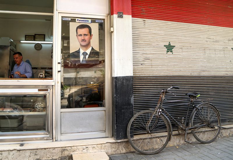 FILE PHOTO: A picture of Syrian President Bashar al-Assad is seen on a door of a butcher shop, during a lockdown to prevent the spread of the coronavirus disease (COVID-19), in Damascus