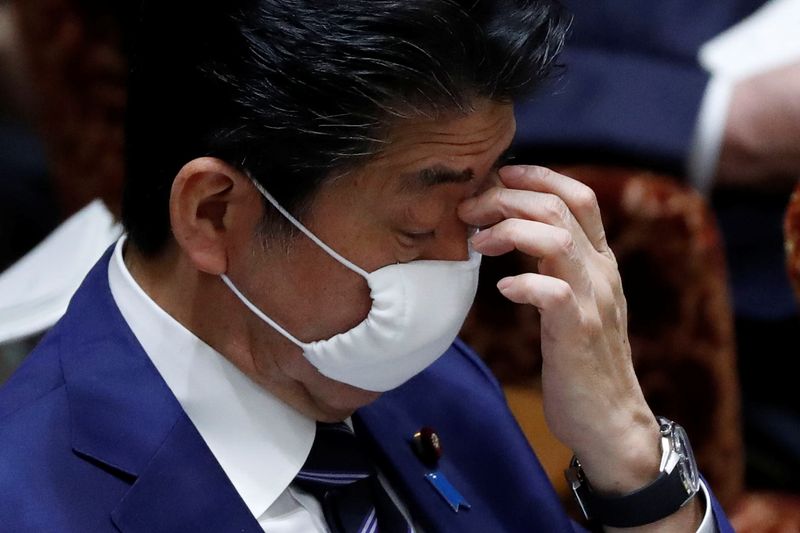 Japan's Prime Minister Shinzo Abe wears a protective face mask as he attends an upper house parliamentary session