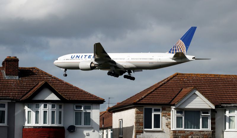 A United Airlines passenger aircraft arrives over the top of residential houses to land at Heathrow Airport in west London