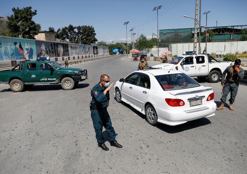 Afghan policemen stand guard at a check point during Eid al-Fitr, a Muslim festival marking the end the holy fasting month of Ramadan, amid the spread of the coronavirus disease (COVID-19), in Kabul