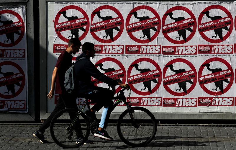 FILE PHOTO: Pedestrians walk past posters on the streets that reads 