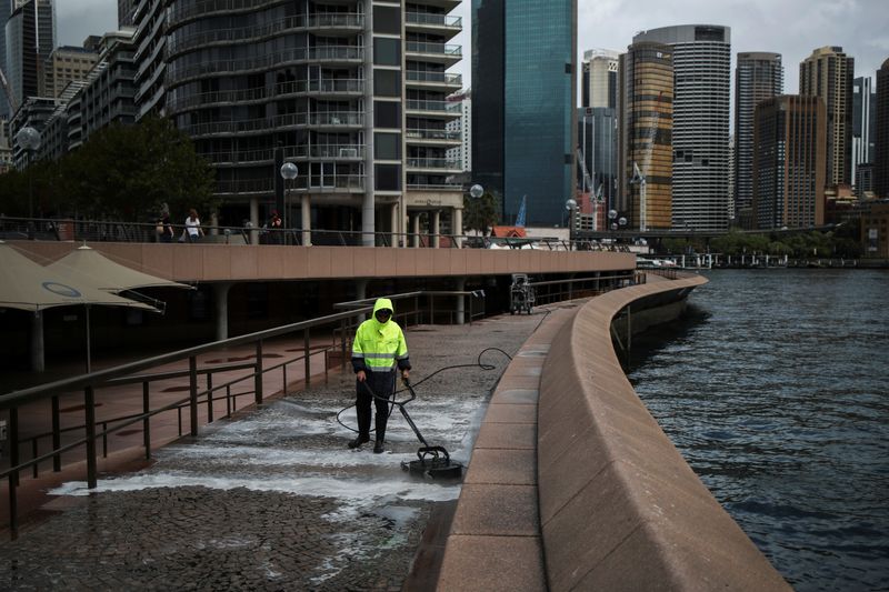 FILE PHOTO: A worker cleans the waterfront area of the Sydney Opera House