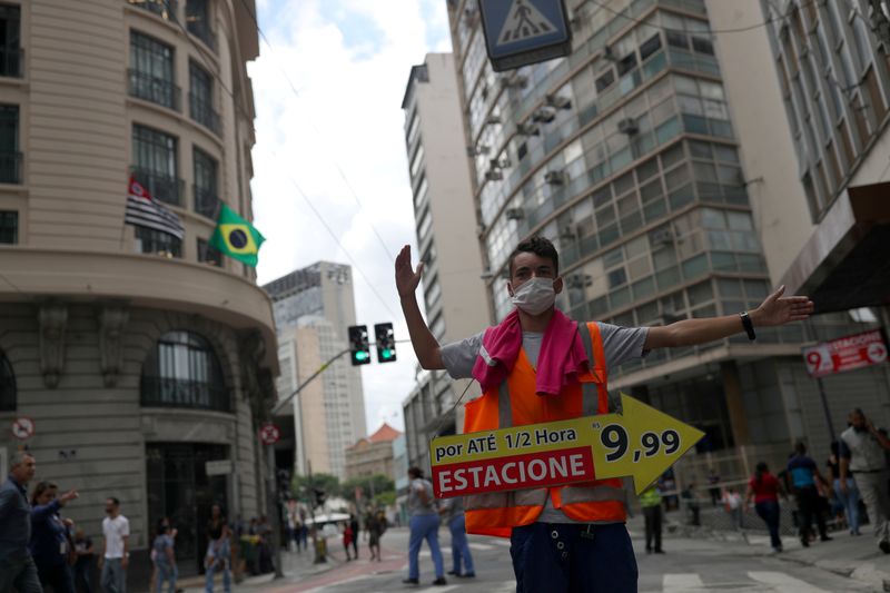 FILE PHOTO: A man wearing protective face mask, as a precautionary measure against coronavirus disease (COVID-19) calls for drivers to park in downtown Sao Paulo
