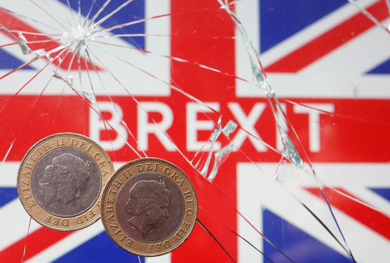 A pound coins are placed on broken glass and British flag in this illustration picture taken