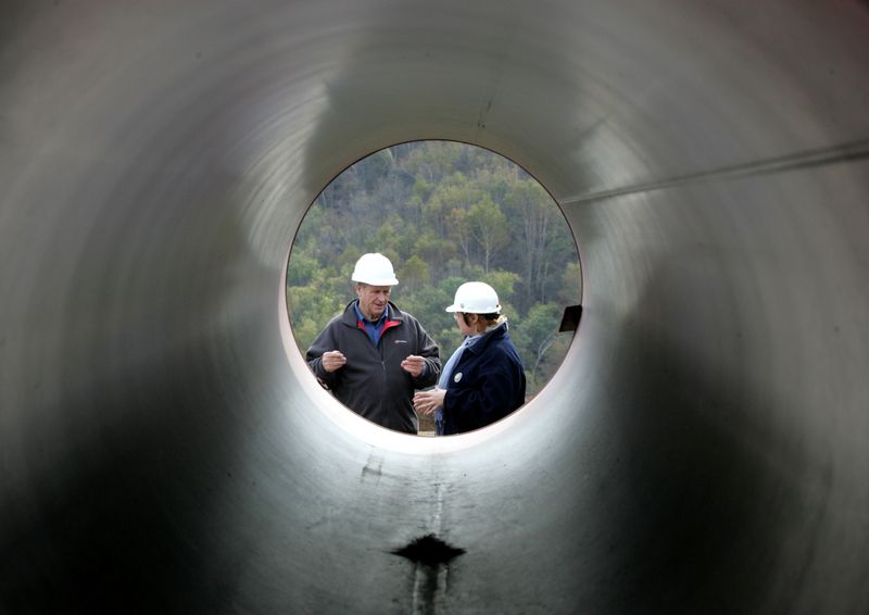 FILE PHOTO: Engineers talk standing next to pipes at a pipeline building site of the Sakhalin-2 project north of Yuzhno-Sakhalinsk