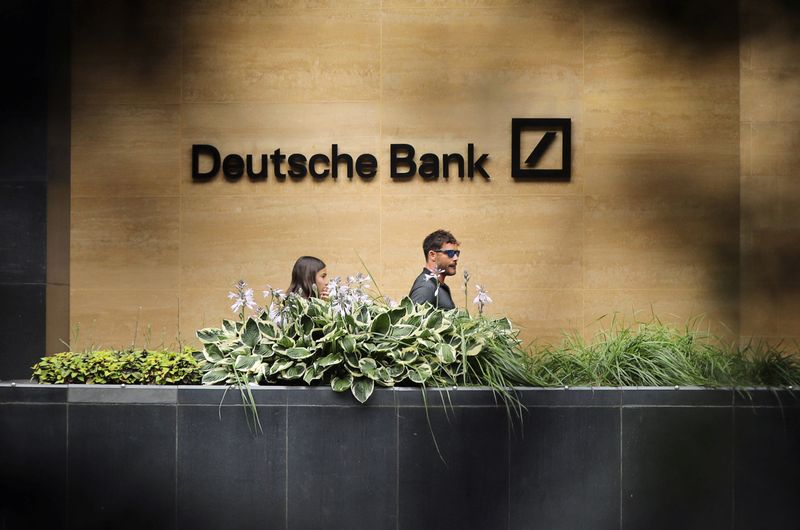 People walk past a Deutsche Bank office in London