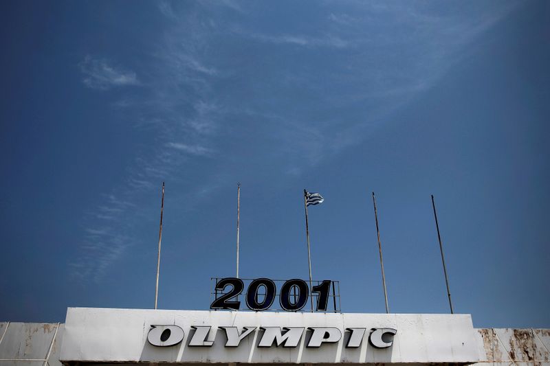 FILE PHOTO: A Greek flag flutters over the main entrance of the former international Hellenikon airport in Athens