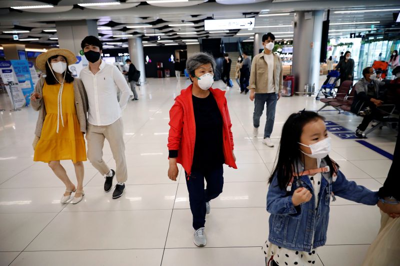 People wearing masks to avoid the spread of the coronavirus disease (COVID-19) arrive at Gimpo international airport in Seoul