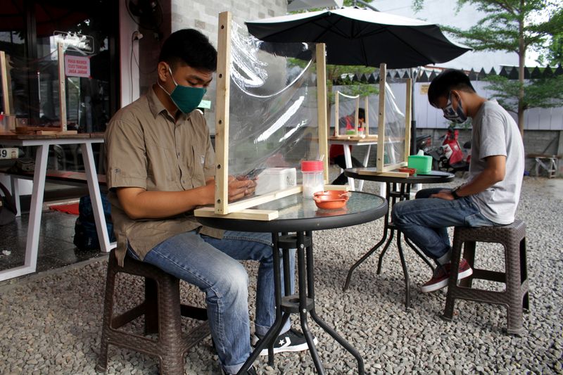 FILE PHOTO: Customers sit with plastic dividers at a cafe to prevent at a cafe the spread of coronavirus disease (COVID-19) outbreak