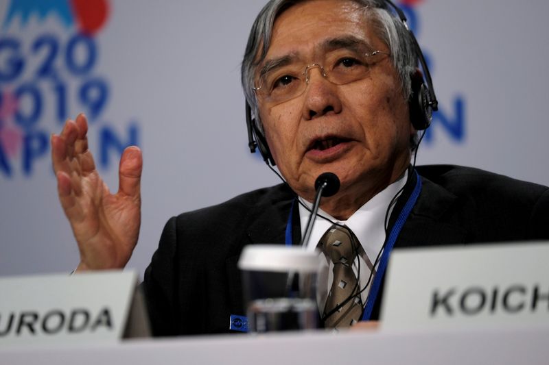 FILE PHOTO: Bank of Japan Governor Haruhiko Kuroda takes questions from reporters at the annual meetings of the International Monetary Fund and World Bank in Washington