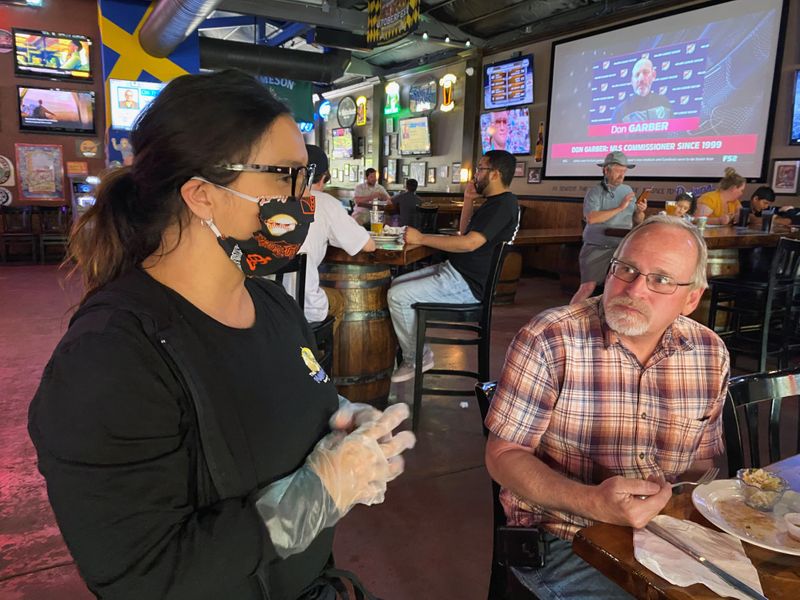 Restaurant owner Sandee Drown talks with customer Tim Schmidt at the Happy Viking Sports Pub and Eatery after opening following coronavirus disease (COVID-19) restrictions in Yuba City