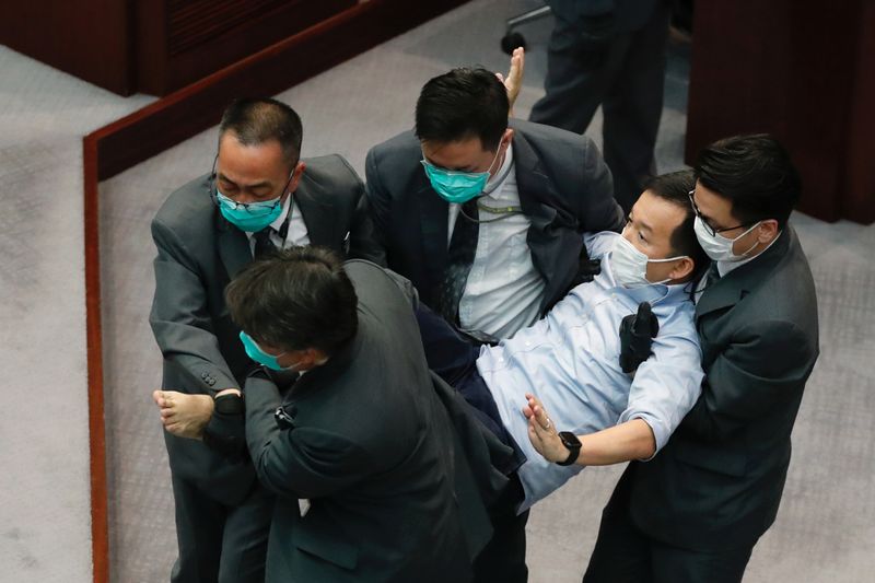 Pan-democratic legislator Raymond Chan Chi-chuen is being taken away by security during a Legislative Council's House Committee meeting, in Hong Kong