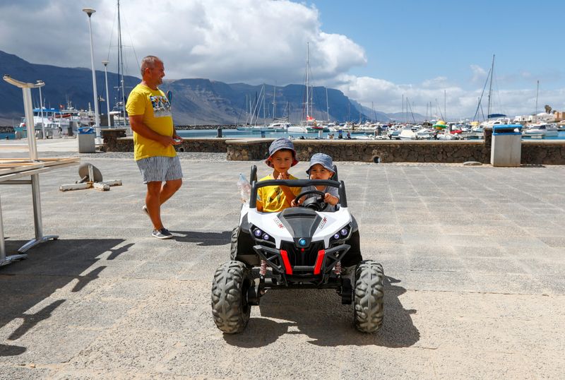 A father plays with his children on a street, as the country relaxes lockdown measures during the outbreak of the coronavirus disease (COVID-19), on the island of La Graciosa