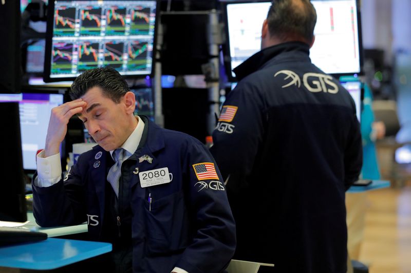 FILE PHOTO: Traders work on the floor of the New York Stock Exchange (NYSE) as the building prepares to close indefinitely due to the coronavirus disease (COVID-19) outbreak in New York