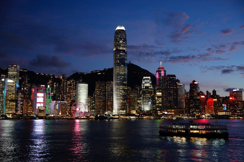 A Star Ferry boat crosses Victoria Harbour in front of a skyline of buildings during sunset, as a meeting on national security legislation takes place in Hong Kong