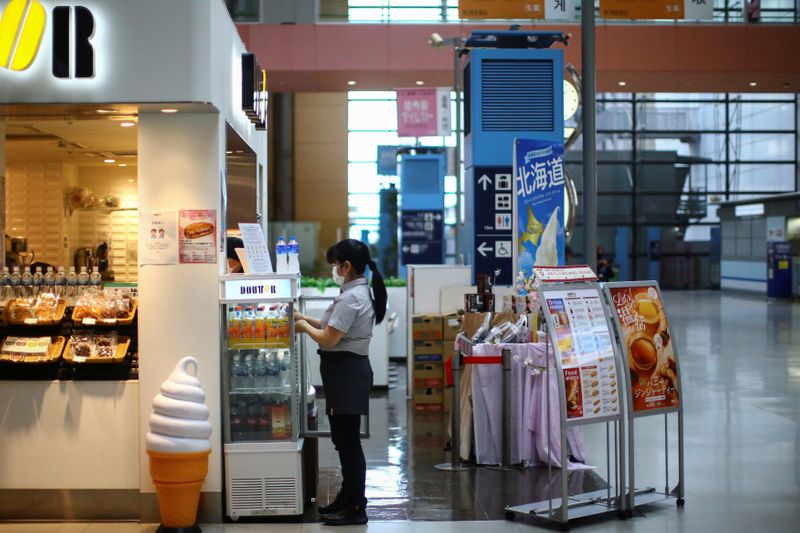 A vendor, wearing protective mask following an outbreak of the coronavirus disease (COVID-19), works at the almost empty Kansai International Airport in Osaka