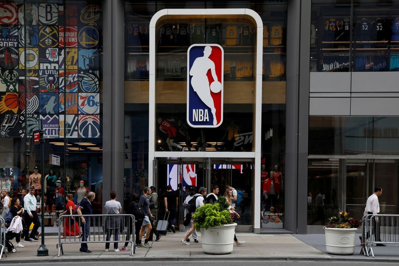 FILE PHOTO: The NBA logo is displayed as people pass by the NBA Store in New York