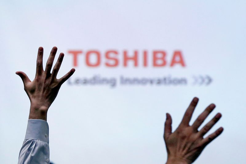 FILE PHOTO: Reporters raise their hands for a question during a news conference by Toshiba Corp CEO Satoshi Tsunakawa at the company headquarters in Tokyo