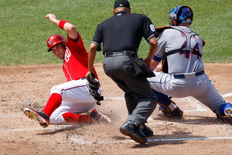 Zimmerman scores ahead of the tag by Mets' Buck during the third inning of their MLB National League baseball game in Washington