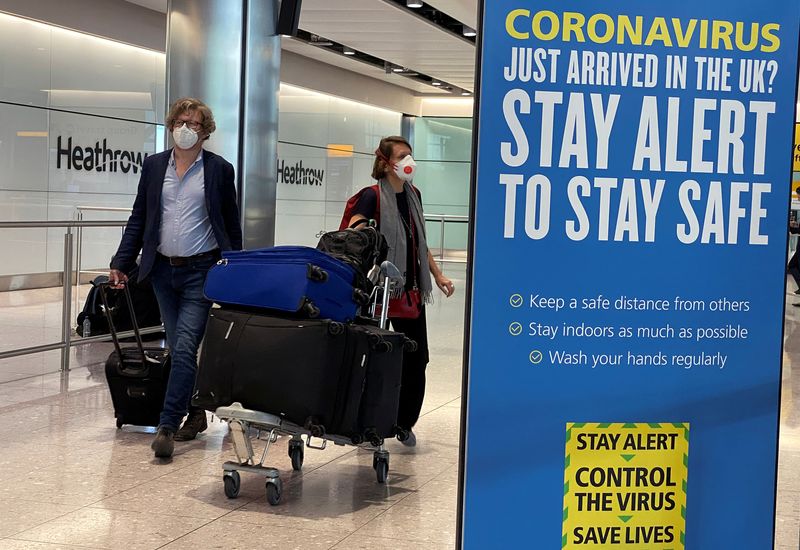 FILE PHOTO: Passengers arrive at Heathrow Airport, as Britain launches its 14-day quarantine for international arrivals, following the outbreak of the coronavirus disease (COVID-19), London, Britain