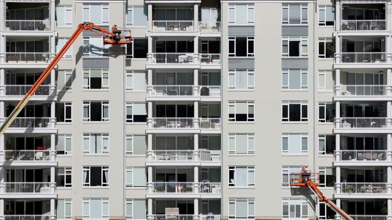 FILE PHOTO: Construction workers put the finishing touches to a new harbourside apartment building in Sydney