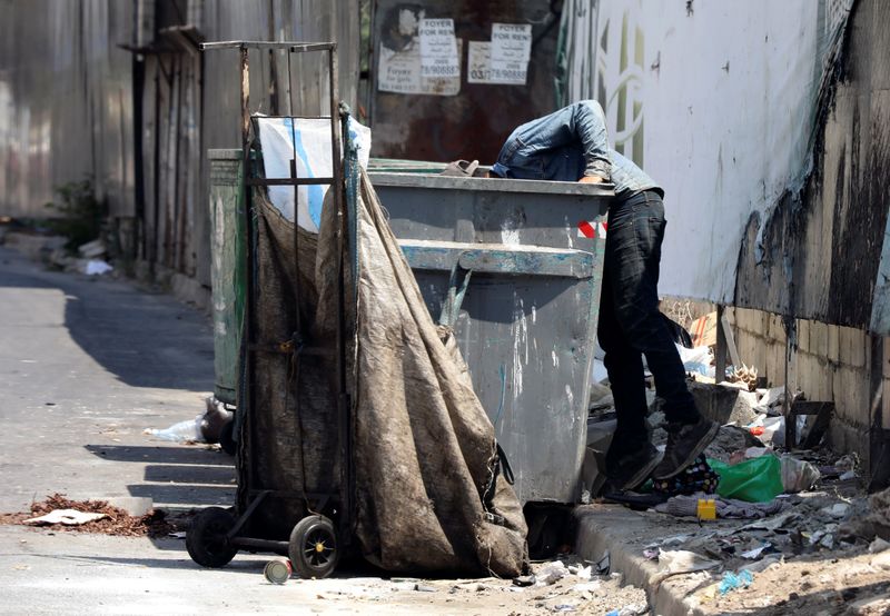 A man searches through a garbage bin in Beirut