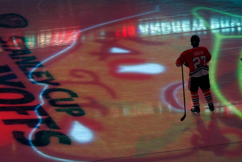 Chicago Blackhawks defenseman Oduya stands in the middle of his team's projected logo in Chicago