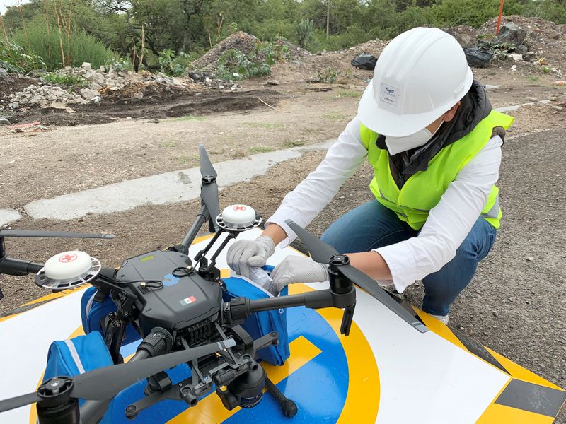 An employee of Sincronia Logistica loads a drone with personal protective gear and other essential equipment for delivery at a public hospital, in Queretaro