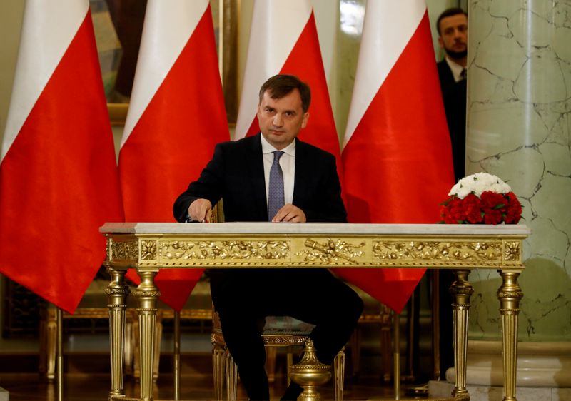 FILE PHOTO: Zbigniew Ziobro signs documents after being designated as Minister of Justice, at the Presidential Palace in Warsaw