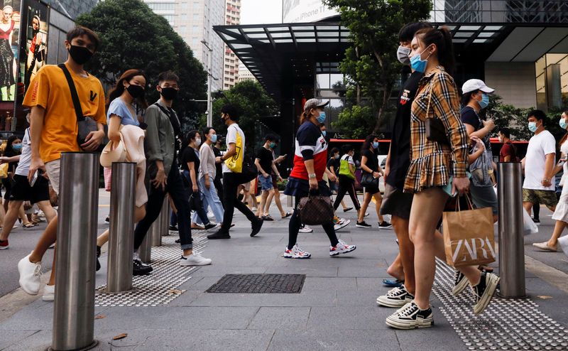 FILE PHOTO: People cross a street at the shopping district of Orchard Road as the city state reopens the economy, amid the coronavirus disease (COVID-19) outbreak, in Singapore