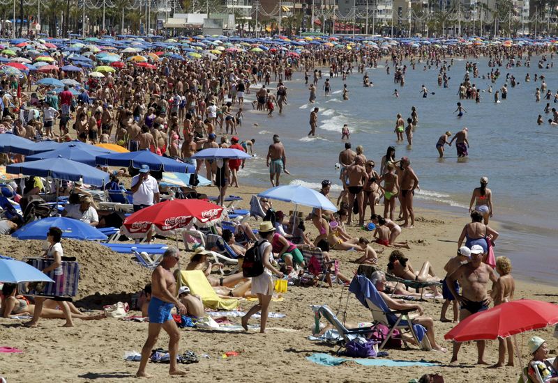 FILE PHOTO: People visit the beach in the Spanish south-eastern town of Benidorm