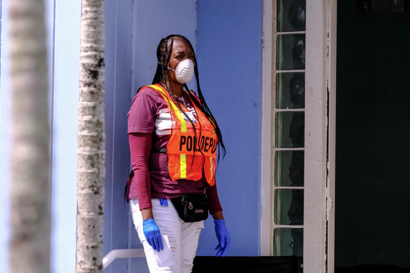 FILE PHOTO: A poll deputy wears gloves and a mask as a preventive measure against the outbreak of coronavirus disease (COVID-19), during the Democratic presidential primary election in Miami