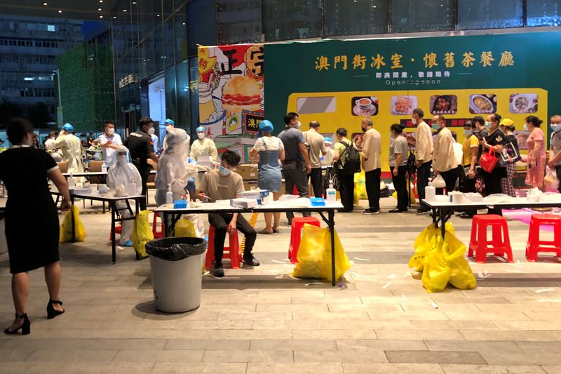 Medical workers wearing protective suits are seen at a nucleic acid testing site outside the IBC Mall in Shenzhen