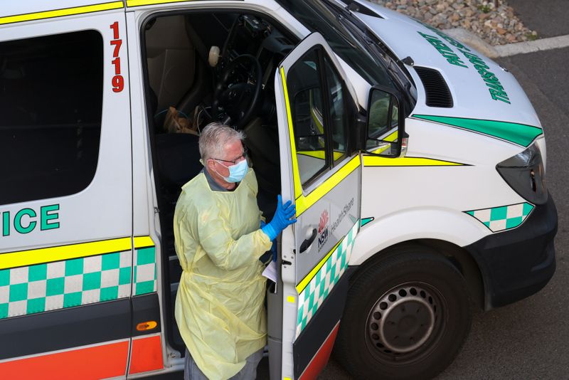 A driver steps out of a patient transport service vehicle outside a quarantine hotel in Sydney