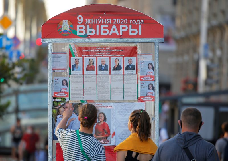 People look at a presidential election information board in Minsk