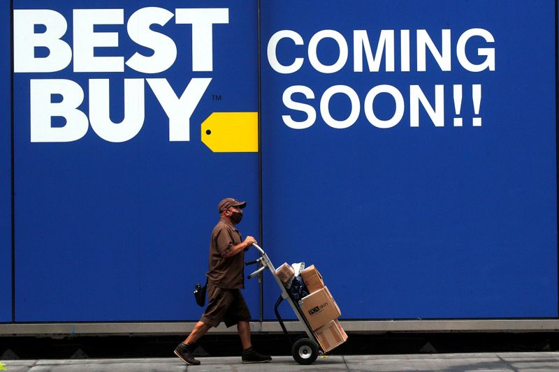 FILE PHOTO: A delivery person passes by a sign for a new Best Buy store in New York