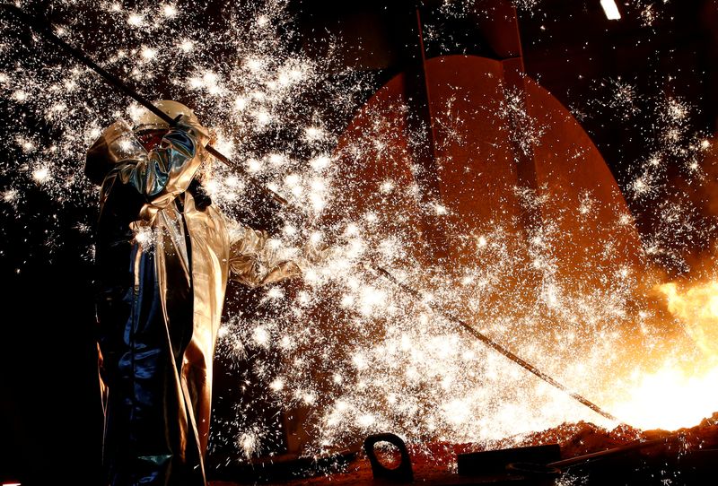 FILE PHOTO: A steel worker of Germany's industrial conglomerate ThyssenKrupp AG stands a mid of emitting sparks of raw iron from a blast furnace at Germany's largest steel factory in Duisburg