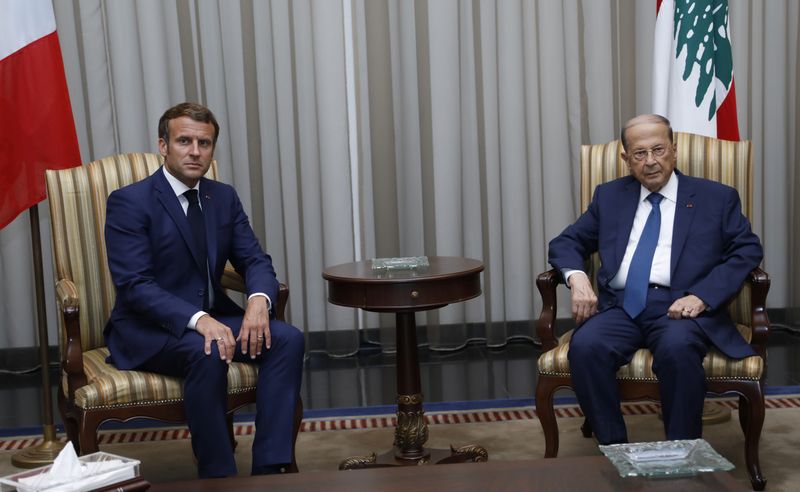 Lebanon's President Michel Aoun meets with French President Emmanuel Macron upon his arrival at the airport in Beirut