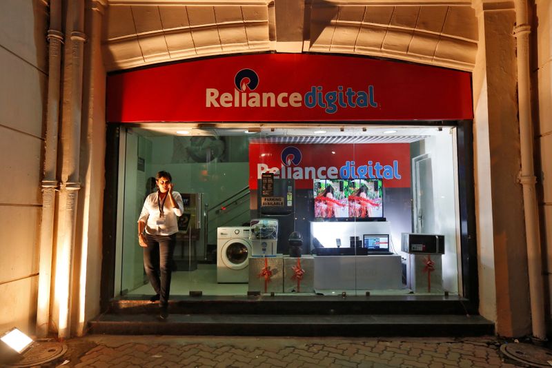 An employee leaves a store of Reliance Industries Ltd, controlled by Mukesh Ambani, one of India's richest men, at a market in Kolkata