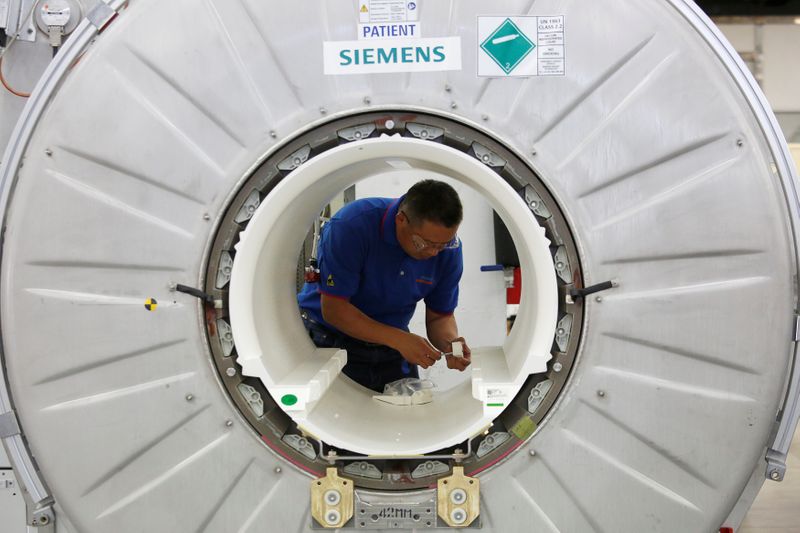 A staffer works on a magnetic resonance imaging machine at a production line of Siemens Healthineers in Shenzhen