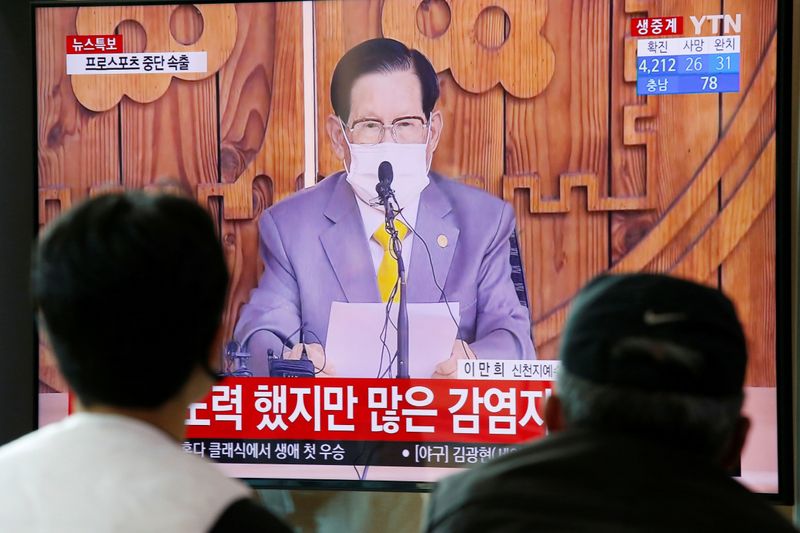 People watch a TV broadcasting a news report on a news conference held by Lee Man-hee, founder of the Shincheonji Church of Jesus the Temple of the Tabernacle of the Testimony, in Seoul