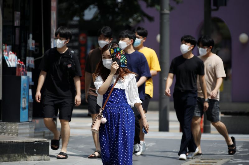 Pedestrians wearing masks to prevent the spread of the coronavirus disease (COVID-19) walk in a shopping district in Seoul