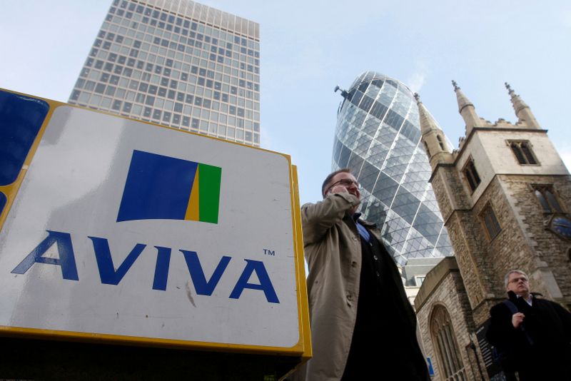 FILE PHOTO: Pedestrians walk past an Aviva logo outside the company's head office in the city of London