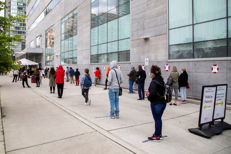FILE PHOTO: People wait in line at a coronavirus disease (COVID-19) testing facility in Toronto.